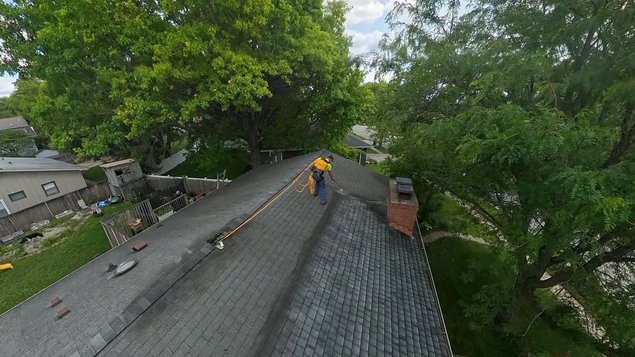 Aerial view of a roof plane half treated, the treated half visibly darker