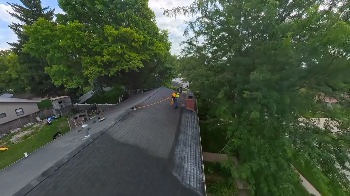 Aerial view of an asphalt shingle roof during rejuvenation treatment