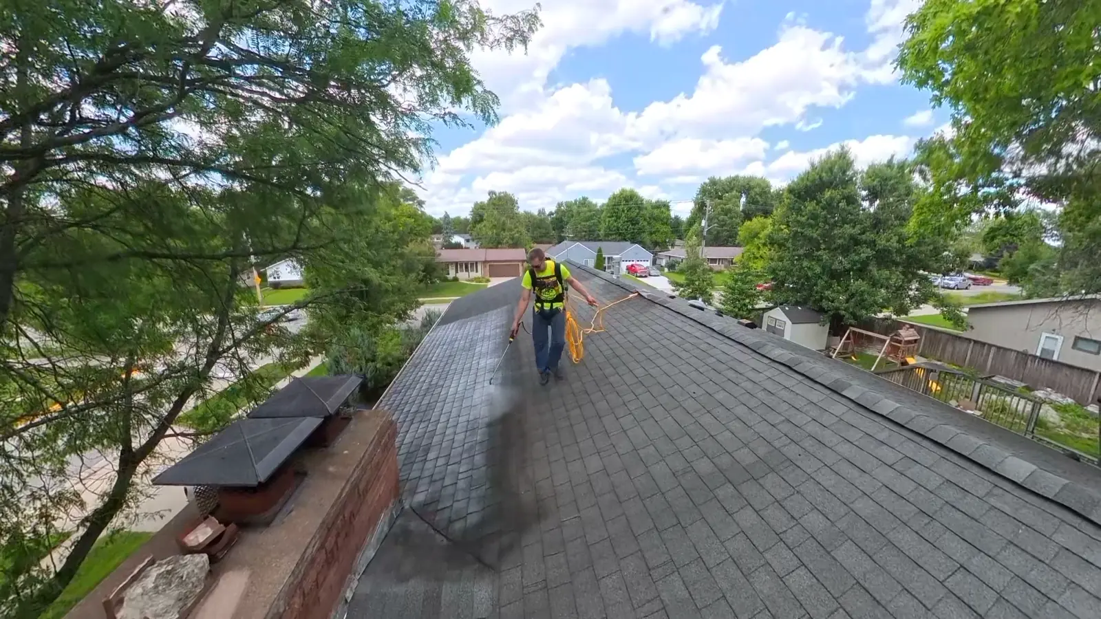 Aerial view of an asphalt shingle roof during a rejuvenation treatment