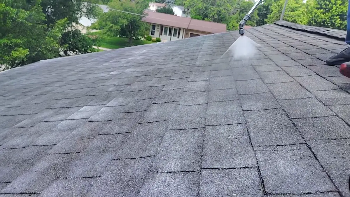 Close-up of shingle treatment being sprayed onto an asphalt roof